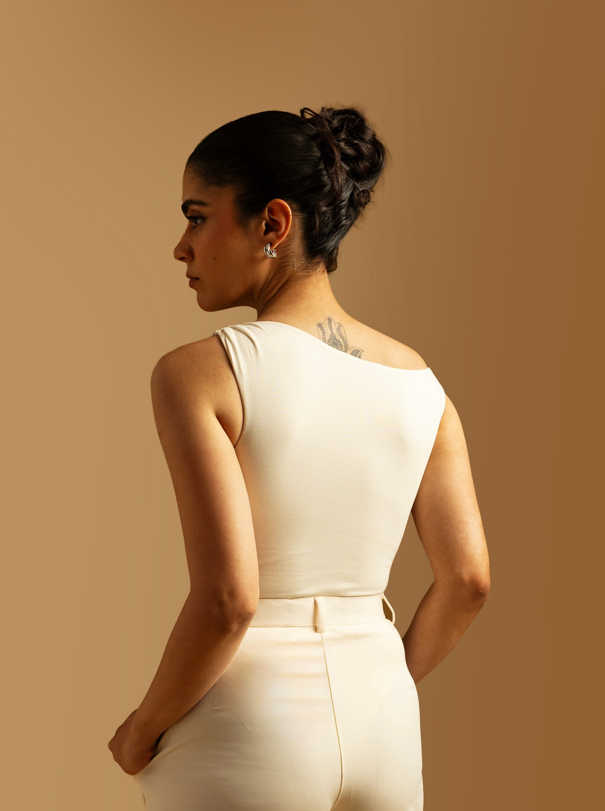 ButterBawd off shoulder bodysuit shown in black with long sleeves and fitted design, highlighting neckline and shoulder details.