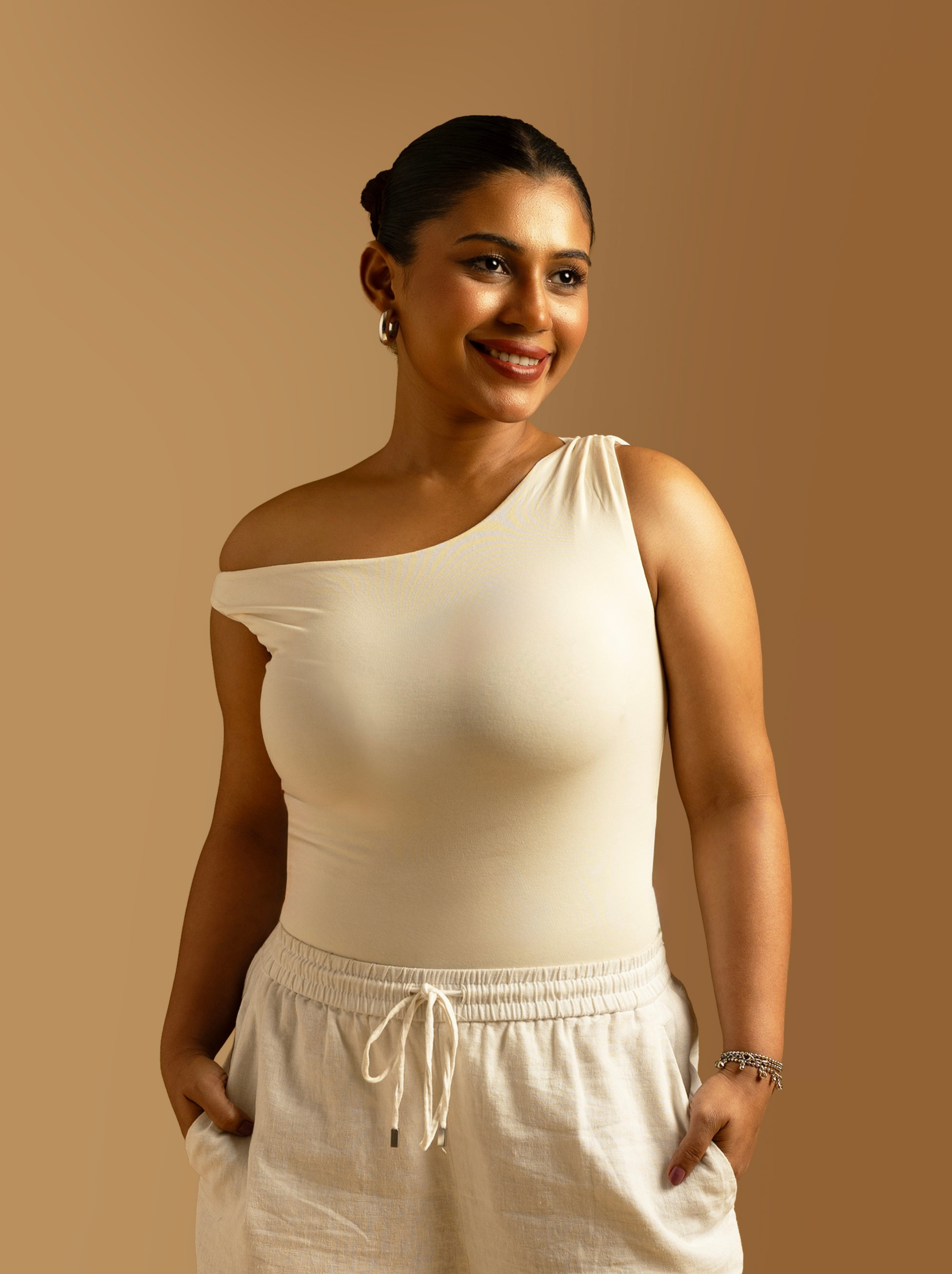 ButterBawd off shoulder bodysuit, black fitted top with long sleeves and off-the-shoulder neckline, close-up view of fabric and design